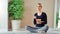 Smiling fitness woman sitting in lotus position eating fresh vegetable salad using fork