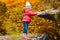 Smiling five year old girl in jacket on autumn yellow leaves background