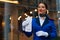 A smiling flight attendant holds a boarding pass. Portrait of a young flight attendant in uniform look into the camera