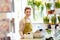 Smiling florist woman at flower shop cashbox