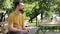 Smiling freelancer in glasses using laptop in park