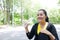 Smiling fresh of Asian young woman in black and yellow sportwear Thirsty and resting and drinking water in bottle after exercise