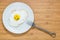 Smiling fried egg lying on a wooden cutting board with morning inscription near it. Classic Breakfast concept.