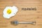 Smiling fried egg lying on a wooden cutting board with morning inscription near it. Classic Breakfast concept.