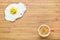 Smiling fried egg lying on a wooden cutting board with small red cup of coffee near it. Classic Breakfast concept.