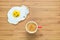 Smiling fried egg lying on a wooden cutting board with small red cup of coffee near it. Classic Breakfast concept.