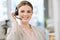 Smiling, friendly call center agent with headset for online consulting in an IT tech agency. Face of female support