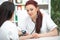 A smiling friendly doctor takes a patient in his office and measures pressure. Woman gives medical advice