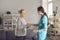 Smiling friendly female doctor nurse greeting handshake senior old lady patient