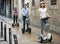 Smiling friends posing on segways on city street