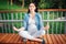 Smiling future mom expecting child sitting cross-legged and meditating with closed eyes outdoors. Prenatal Yoga. Healthy