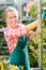 Smiling garden center woman working potted flowers