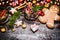 Smiling gingerbread men with mug of mulled wine , Christmas decoration and holiday cookies and spices on dark rustic background wi