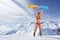 Smiling girl in bikini holding snowboard above head