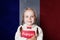 Smiling girl with book against French flag banner