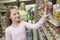 Smiling Girl Choosing Products From Supermarket Shelf