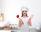 Smiling girl in cook hat with ladle and whisk