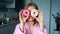 Smiling girl covering his eyes with glazed donuts. Pretty woman having fun
