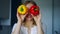 Smiling girl covering his eyes with paprika peppers. Vegetable diet concept