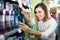 smiling girl customer looking for effective mouthwash in supermarket