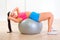 Smiling girl doing abdominal crunch on fit ball