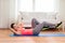 Smiling girl doing exercise on floor at home