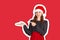 Smiling girl in dress shows the finger. emotional girl in santa claus christmas hat Magazine collage style with trendy color