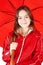 Smiling girl dressed in raincoat holding umbrella