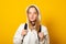 Smiling girl dressed white hoodie on yellow  background with backpack. Positive cool schoolgirl