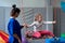 Smiling girl enjoying sensory therapy on a swing when physiotherapist helps her