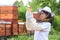 Smiling girl examining honey jar in apiary