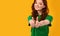 Smiling Girl Gesturing Thumbs-Up Approving Something Standing Over Yellow Background