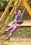 Smiling girl hanging on climbing frame