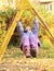 Smiling girl hanging on climbing frame