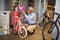 Smiling girl and her grandfather buying bicycle and helmets in bike shop