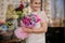 Smiling girl holding a bouquet of crimson orchid and violet hyacinth