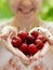 Smiling girl holding a handful of cherries