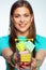 Smiling girl holding little market cart with many miniature gift boxes.