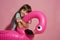Smiling girl hug inflatable flamingo rubber ring