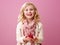 Smiling girl isolated on pink background showing raspberries