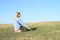 Smiling girl kneeling on meadow