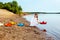 Smiling girl launches paper boat in lake