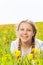 Smiling girl laying in dandelions meadow