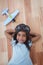 Smiling girl laying on the floor wearing aviator glasses and hat