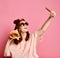 Smiling girl in lifestyle clothes taking picture self portrait on smartphone with burger sandwich