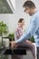 Smiling girl looking at father washing hands in kitchen