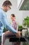 Smiling girl looking at father washing hands in kitchen