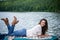 Smiling girl lying on boat in the middle of the lake