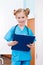 Smiling girl nurse holding clipboard in hospital chamber