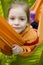 Smiling girl in orange hammock in forest